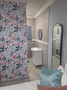 a bathroom with a sink and a wall with flowers at 310 Bonnyvale in Kempton Park