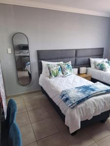 a bedroom with a bed with a mirror and a mirror at 310 Bonnyvale in Kempton Park