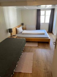 a bedroom with a large bed in a room with rugs at Hotel Central in Luchsingen +3 photos