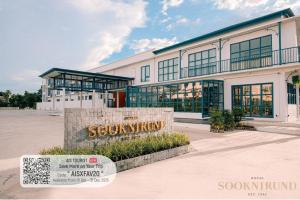 Un gran edificio con un cartel delante. en SOOKNIRUND HOTEL, en Chiang Rai