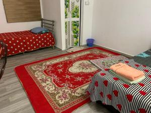 a room with a red rug on the floor at Aydan Homestay in Kampong Bagan