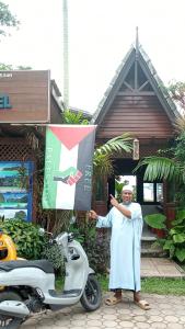 a man holding a flag next to a scooter at Baan Pakgasri Hideaway in Ko Lanta