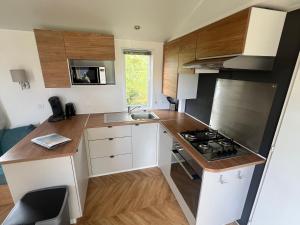 a small kitchen with a stove and a sink at 6-Pers chalet Lauwersoog in Lauwersoog