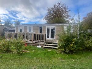 a tiny house with a porch and a deck at 6-Pers chalet Lauwersoog in Lauwersoog