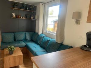 a living room with a blue couch and a window at 6-Pers chalet Lauwersoog in Lauwersoog