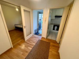 una camera con corridoio, porta e cucina di Basic & Comfy on Langgrütstrasse a Zurigo Altre 4 foto