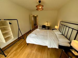 una camera da letto con un letto bianco e un pavimento in legno di Basic & Comfy on Langgrütstrasse a Zurigo