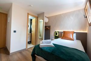a bedroom with a bed with a green blanket at Negresco Plaza Mayor in Madrid