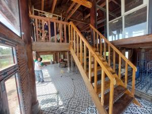 a wooden staircase in a building with a group of people at The wooden house, peaceful place in Nhon Trach IoStayhome in Kon Rung (1)