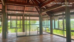a large room with glass windows and a wooden floor at The wooden house, peaceful place in Nhon Trach IoStayhome in Kon Rung (1)