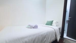 a white bed with a towel on top of it at The Breakout Room ICE BSD in Serpong +4 photos