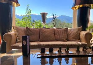 - un canapé dans le salon doté d'une grande fenêtre dans l'établissement Litohoro Olympus Resort Villas & Spa, à Plaka Litochorou