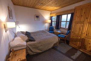 Un dormitorio con una cama y un escritorio y una ventana. en Lemonsjø Fjellstue og Hyttegrend, en Randsverk