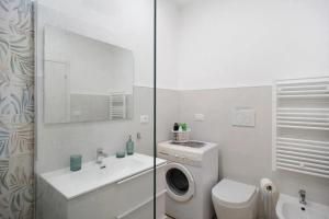 a white bathroom with a washing machine and a sink at Casa Thea in Santo Stefano al Mare +12 photos