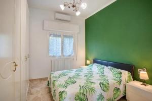 a green bedroom with a bed and a green wall at Casa Thea in Santo Stefano al Mare
