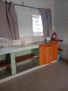 eine Küche mit einer Theke mit Spüle und einem Fenster in der Unterkunft Katawa Cottage in Monkey Bay