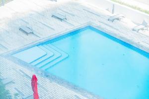 een uitzicht over een zwembad met twee banken bij Sustainable Luxury 1BR Reem Island Stay 4 Guest in Abu Dhabi