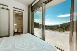 a bedroom with a bed and a large window at Villa Roya in Sivota +36 photos