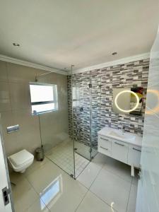 a bathroom with a shower and a toilet and a sink at 4-bedroom in the center of the Southern Suburbs! in Cape Town