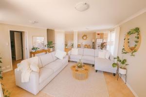 a living room with a white couch and a table at Waterfront bliss, spacious corner block in Mandurah +16 photos