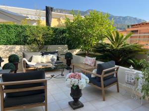 a patio with chairs and a table with flowers at Grace & Breakfast Monaco in Beausoleil