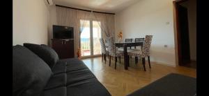 ein Wohnzimmer mit Tisch und Stühlen und einer Couch in der Unterkunft Haus ''Mira'' in Pinezici