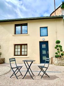 two chairs and a table in front of a house at La Petite Lorraine in Bertrambois