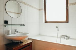 a bathroom with a sink and a tub and a mirror at Au pied du pré, Appartement 6P in Verviers