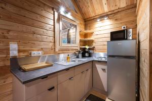 a kitchen with a refrigerator and a sink at Huttopia Champagny en Vanoise in Champagny-en-Vanoise