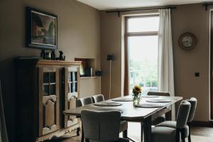 a dining room with a table and chairs and a window at Au pied du pré, Appartement 6P in Verviers +10 photos