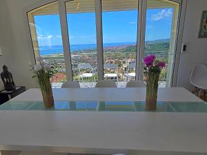 une table blanche avec trois vases de fleurs dessus dans l'établissement Villa con piscina privada climatizada 29ºC, à Santa Susanna 43 autres photos