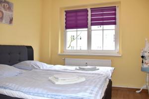 a bedroom with a bed and a window with purple blinds at GUWO Gästewohnung Friedrich-Engels-Str 5 in Sprucke