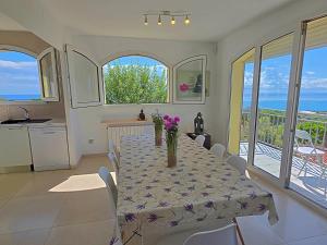 a dining room with a table with purple flowers on it at Villa con piscina privada climatizada 29ºC in Santa Susanna
