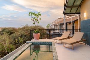 a balcony with two chairs and a pool at O2 Villas Yala in Yala