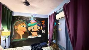 a bedroom with a painting of a monkey on the wall at Ghumakkad Jodhpur in Jodhpur