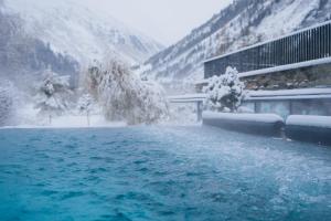 una persona che salta in una piscina nella neve di Boutique Hotel Mandarfnerhof a Sankt Leonhard im Pitztal