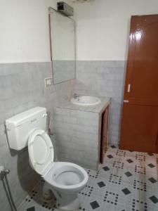 a bathroom with a toilet and a sink at Kodai ARYASREE in Kodaikānāl