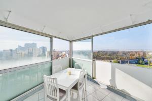 a white table and chairs on a balcony with windows at Créteil Panorama - Center de Créteil in Créteil +4 photos
