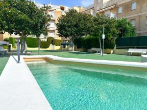 a swimming pool with blue water in front of a building at Apartment Sunset in Cunit