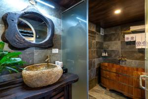 a bathroom with a large stone sink and a tub at Sapana Mountain Retreat in Sapa