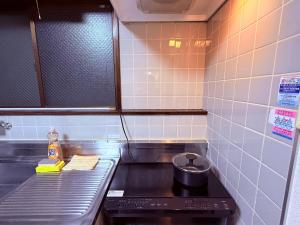 a kitchen with a stove with a pot on it at Stay Plus Sophia in Utsunomiya