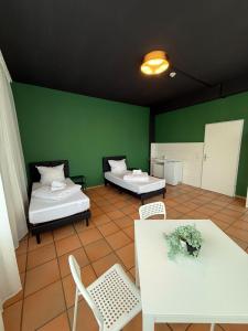 una habitación con dos camas y una mesa y sillas en CrownLiving Babylon Studios, en Lustenau