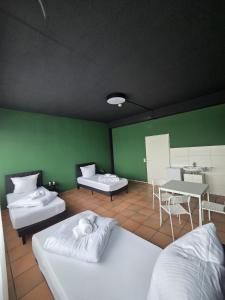 Una habitación con dos camas y una pared verde. en CrownLiving Babylon Studios, en Lustenau