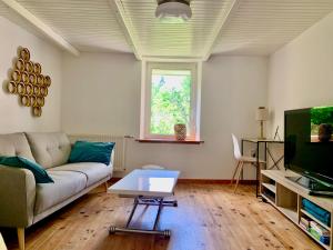 a living room with a couch and a table at La Petite Lorraine in Bertrambois