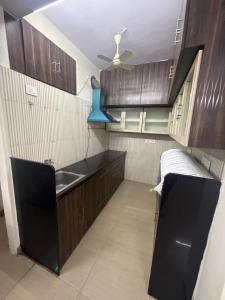 een keuken met houten kasten en een spoelbak bij Sita stays in Vijayawāda +2 foto's