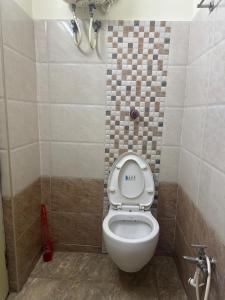 een badkamer met een toilet met de bril omhoog bij Sita stays in Vijayawāda