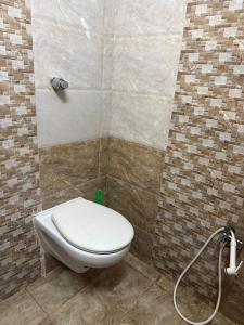 een badkamer met een wit toilet in een kamer bij Sita stays in Vijayawāda