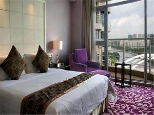 Habitación de hotel con cama y silla morada en Hiyet Oriental Hotel, en Zhongshan
