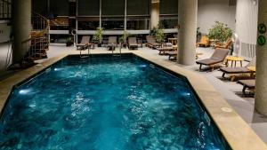 a swimming pool in a lobby with chairs and tables at Grand Hotel Bucharest in Bucharest