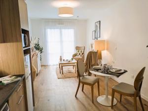 シェルにあるRésidence de Chellesのテーブルと椅子のあるキッチンとリビングルーム